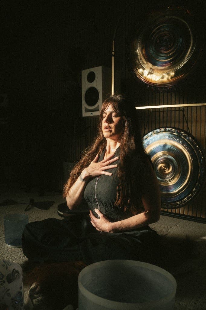 Practicante de breathwork sentada con gongs en Sacred Society